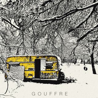 forest covered in snow, we see a yellow trailer and a tyre hanged on a branch so kids can swing.